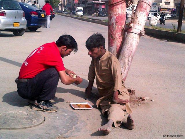 A Pakistani waiter at a restaurant provides food to a man.