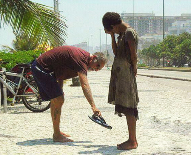 A man giving his shoes to a homeless girl in Rio de Janeiro