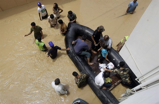 Pakistani soldiers rescue local residents from an area flooded by heavy rains on the outskirts of Karachi