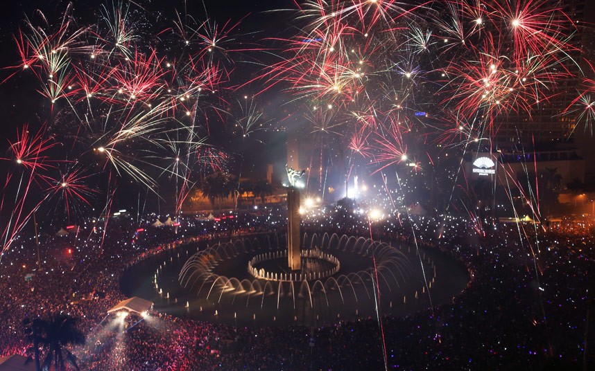 Fireworks explode as thousands of people gather to watch in the main business district on New Year's Eve in Jakarta, Indonesia