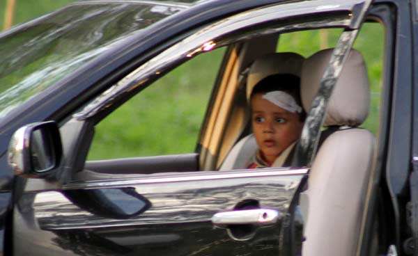 A kid sitting in the car belonging to unidentified man having firearms (not in picture) who kept traffic and business activities on the point in Blue Area suspended for many hours.