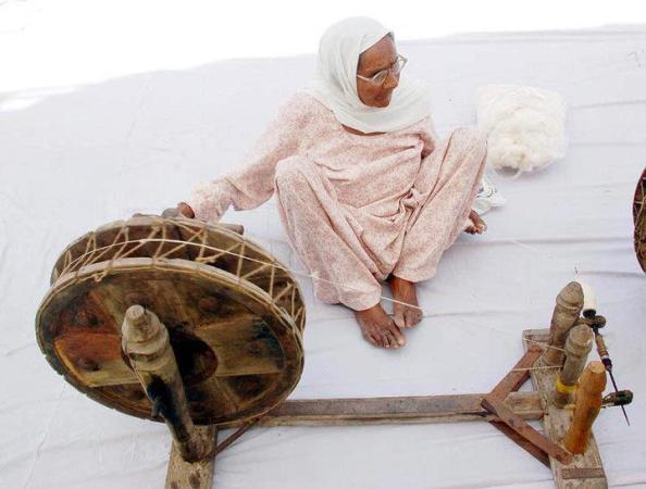 An Old Lady Spinning Charkha in Village